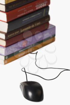 Close-up of a stack of books and a computer mouse