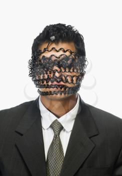 Businessman's face wrapped with telephone cord