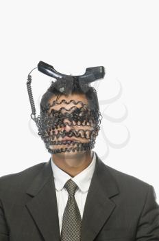 Businessman's face wrapped with telephone cord with it's receiver on his head
