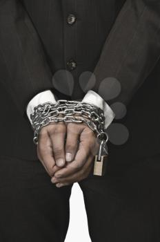 Close-up of a businessman's hands locked with chains