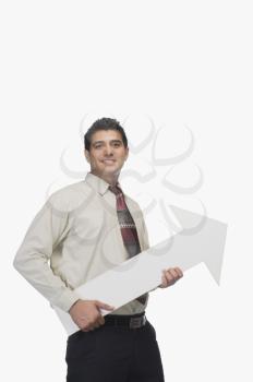 Portrait of a businessman smiling and holding an arrow sign