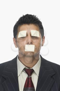 Adhesive notes on the eyes and mouth of a businessman