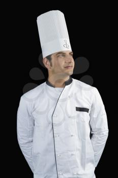 Chef standing with hands behind back and smiling