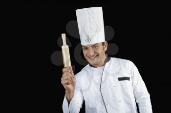 Portrait of a chef holding a rolling pin