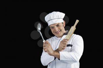 Chef holding a rolling pin and a ladle