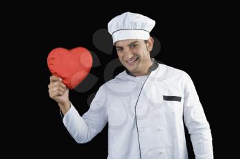 Portrait of a chef holding a heart shape gift
