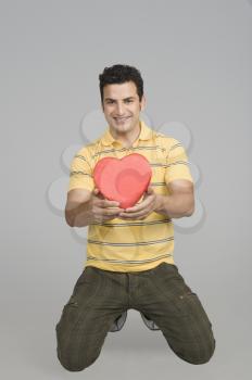 Man proposing with a heart shape gift
