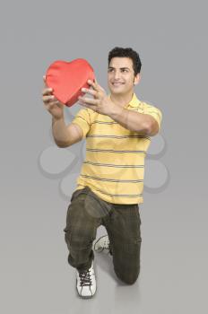 Man proposing with a heart shape gift
