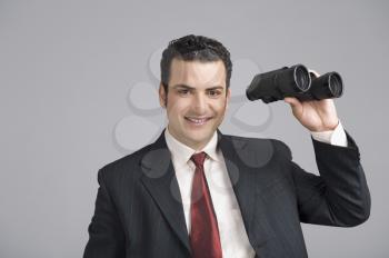 Businessman holding binoculars