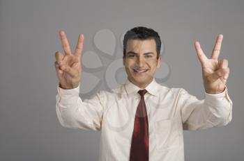 Portrait of a businessman showing victory sign