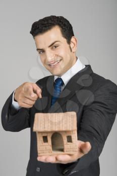 Businessman pointing towards a model home