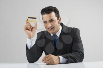 Portrait of a businessman showing a credit card