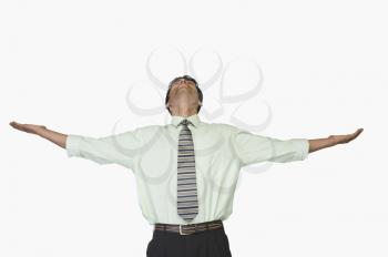 Businessman looking up with his arms outstretched