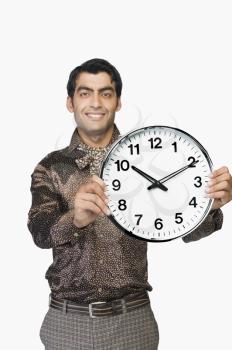 Portrait of a businessman showing a clock