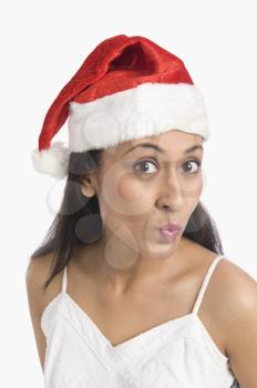 Close-up of a woman wearing a Santa hat and puckering