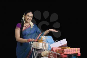 Woman carrying Diwali gifts in a shopping cart