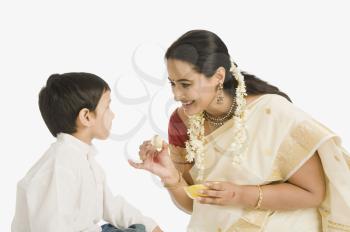 Woman feeding sweet to her son