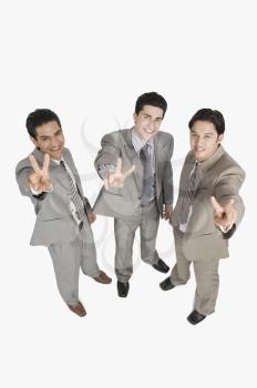 Portrait of three businessmen making peace signs
