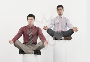 Two businessmen practicing yoga