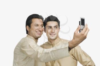 Two men taking a picture of themselves with a mobile phone