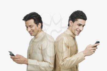 Two men text messaging on mobile phones