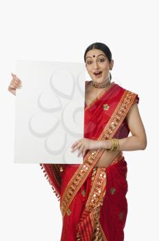 Woman in red mekhla holding a placard