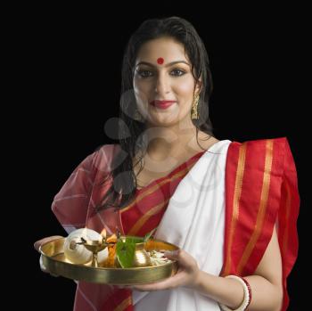 Beautiful woman in a Bengali sari holding pooja thali