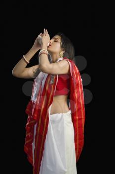 Woman in a Bengali sari blowing conch shell