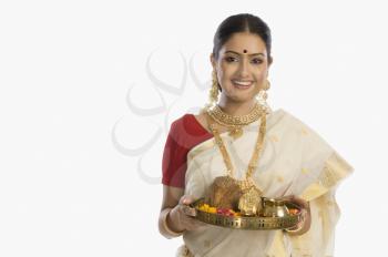 Portrait of a South Indian woman holding a plate of religious offerings
