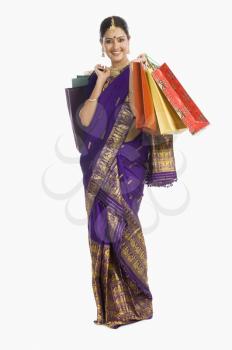 Beautiful Assamese woman holding shopping bags and smiling