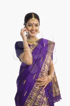 Woman wearing mekhla and talking on a mobile phone