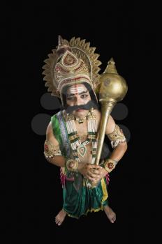 Portrait of a stage artist dressed-up as Ravana and holding a mace