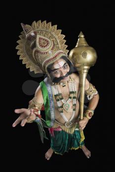 Portrait of a stage artist dressed-up as Ravana and holding a mace