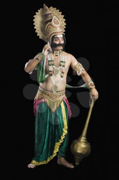 Man dressed-up as Ravana talking on a mobile phone