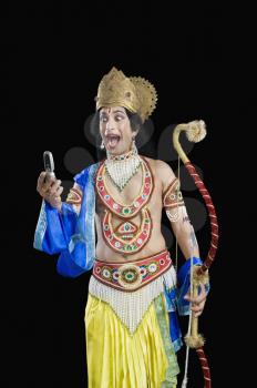 Man dressed-up as Rama reading text message