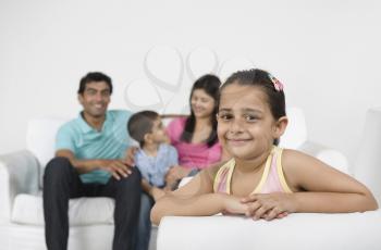 Portrait of a girl smiling with her family in the background
