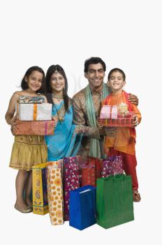 Family holding shopping bags and gifts for Diwali