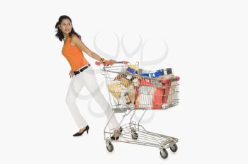 Woman pulling a shopping cart and smiling