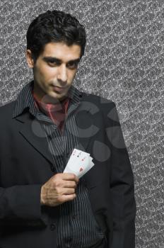 Portrait of a man holding three aces