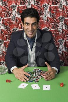Portrait of a man smiling and collecting won gambling chips