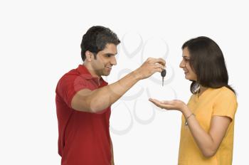 Man giving a car key to woman
