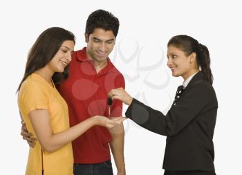 Businesswomen giving a car key to a woman