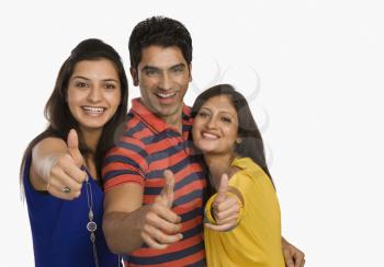 Portrait of three friends showing thumbs up sign