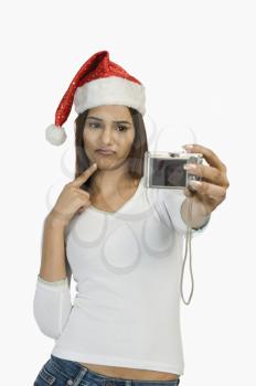 Woman taking a picture of herself with a digital camera