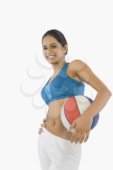 Woman holding a volleyball and smiling
