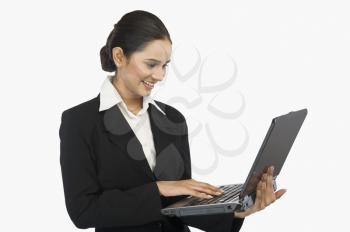 Close-up of a businesswoman using a laptop and smiling
