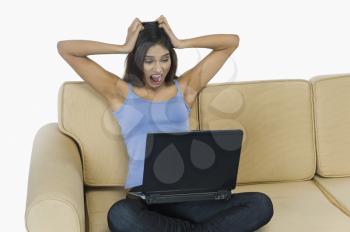 Woman using a laptop and looking irritated