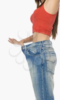Mid section view of a woman pulling her jeans