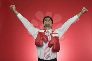 Businessman with boxing gloves clenching his fists