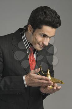 Close-up of a businessman holding a magic lamp